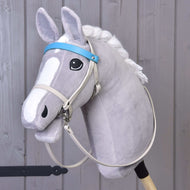 Grijze Hobby Horse met crème kunstleren hoofdstel, aquablauwe frontriem en lange crème teugels, schuin van voren