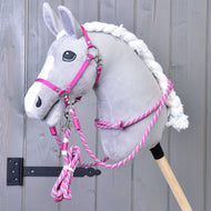 Un Hobby Horse gris en peluche, liste blanche et crinière tressée, porte le licol rose et les rênes en corde du Set Start Rose