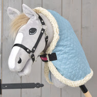 Hobby Horse gris au licol noir portant la couverture d'écurie Sky Blue matelassée bleu clair, bordée de polaire crème