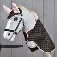 Hobby Horse gris au licol noir portant l’ensemble Thermo Sweety, couverture brune matelassée et bonnet d’oreilles aux oreilles roses