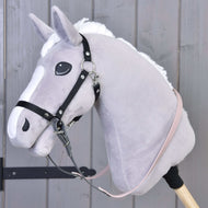Hobby Horse van grijs pluche met zwarte halster en gerubberde teugels in donkergrijs en lichtroze, vastgegespt aan de ringen