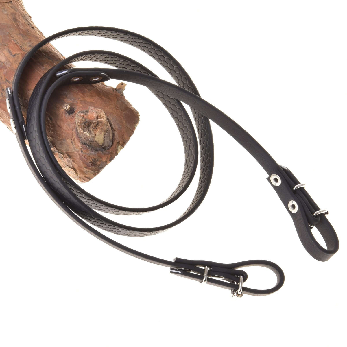 Rênes caoutchoutées noires LarDen pour Hobby Horse, texture nid d’abeille et boucles argentées, posées sur une branche