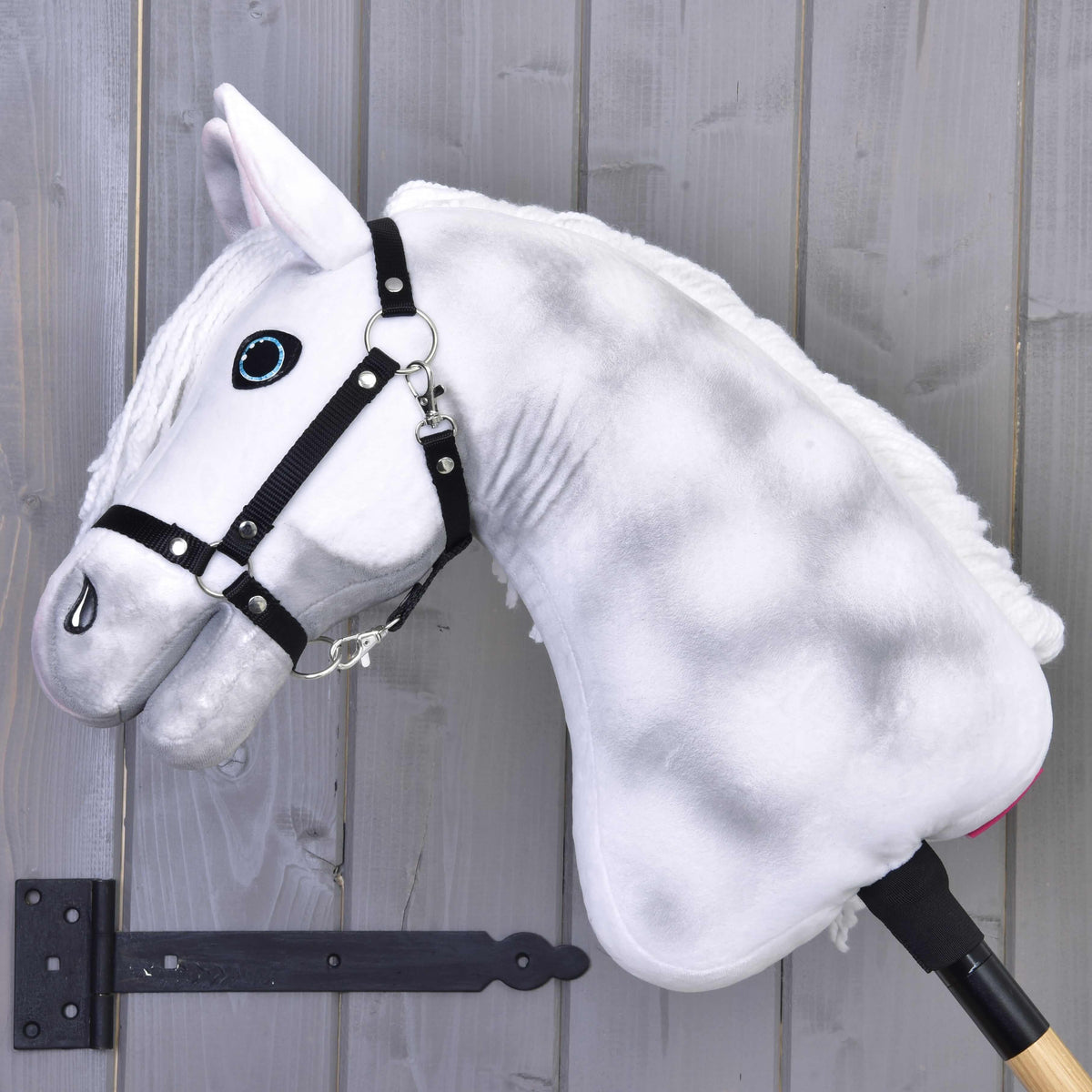 Hobby Horse Elektra avec licol noir vu de côté, avec de douces pommelures grises sur l’encolure en peluche blanche
