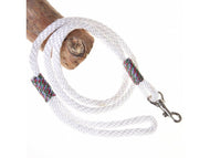 Hobby Horse Halstertouw wit van LarDen van wit gevlochten touw met regenboogkleurige omwikkeling en musketon, over een tak