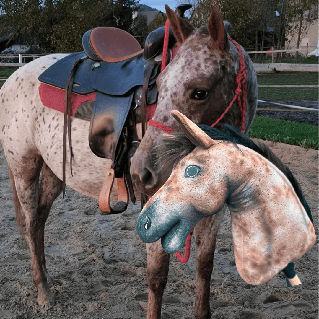 Gevlekt paard met rode touwhalster op een zandbak achter zijn gespikkelde kopie als Hobby Horse met donkere manen