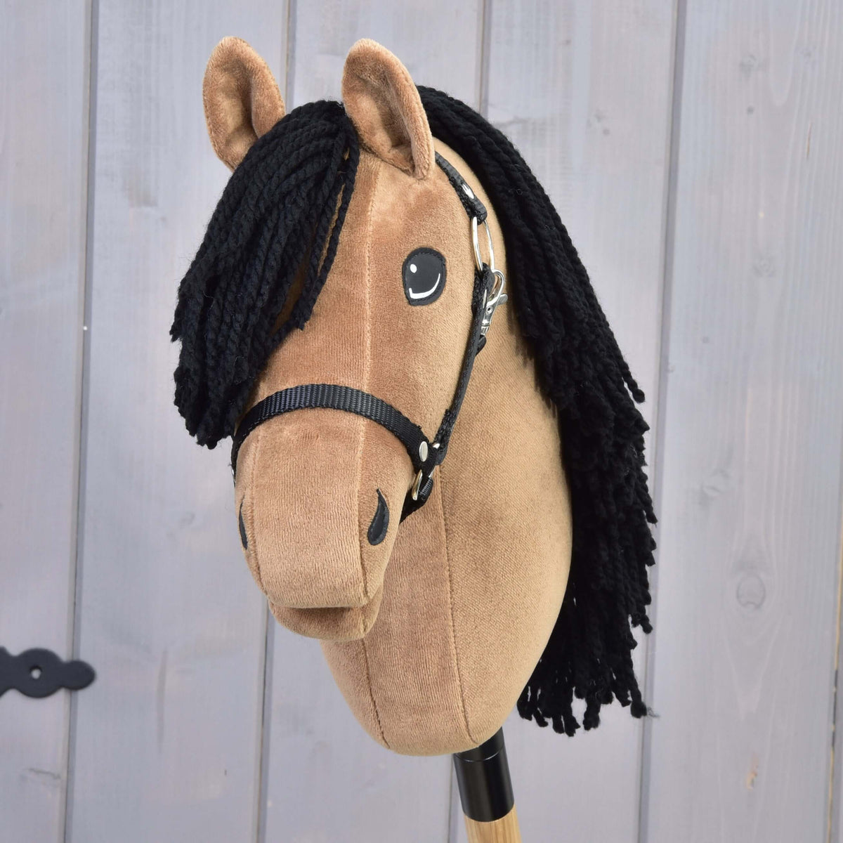 Hobby Horse Samantha schuin van voren met zwarte lok van garen, lachend oog en zwart halster