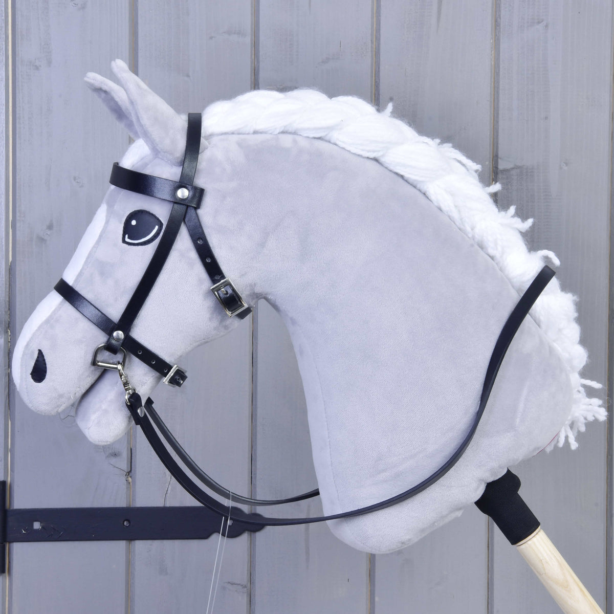 LarDen Hobby Horse compleet zwart hoofdstel van kunstleer met lange teugels op een lichtgrijs pluchen paard met gevlochten witte manen