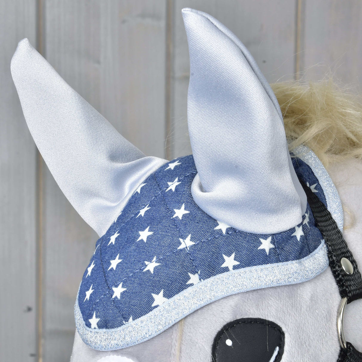 Gros plan du bonnet d’oreilles Star sur un Hobby Horse gris : oreilles en satin argent, imprimé étoiles et bord argent pailleté