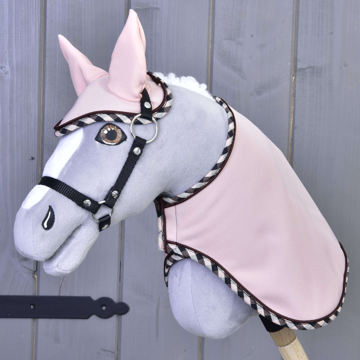 Grijze Hobby Horse met amberkleurige ogen en zwart halster in de Set Abby, lichtroze deken en oornetje met geruite rand