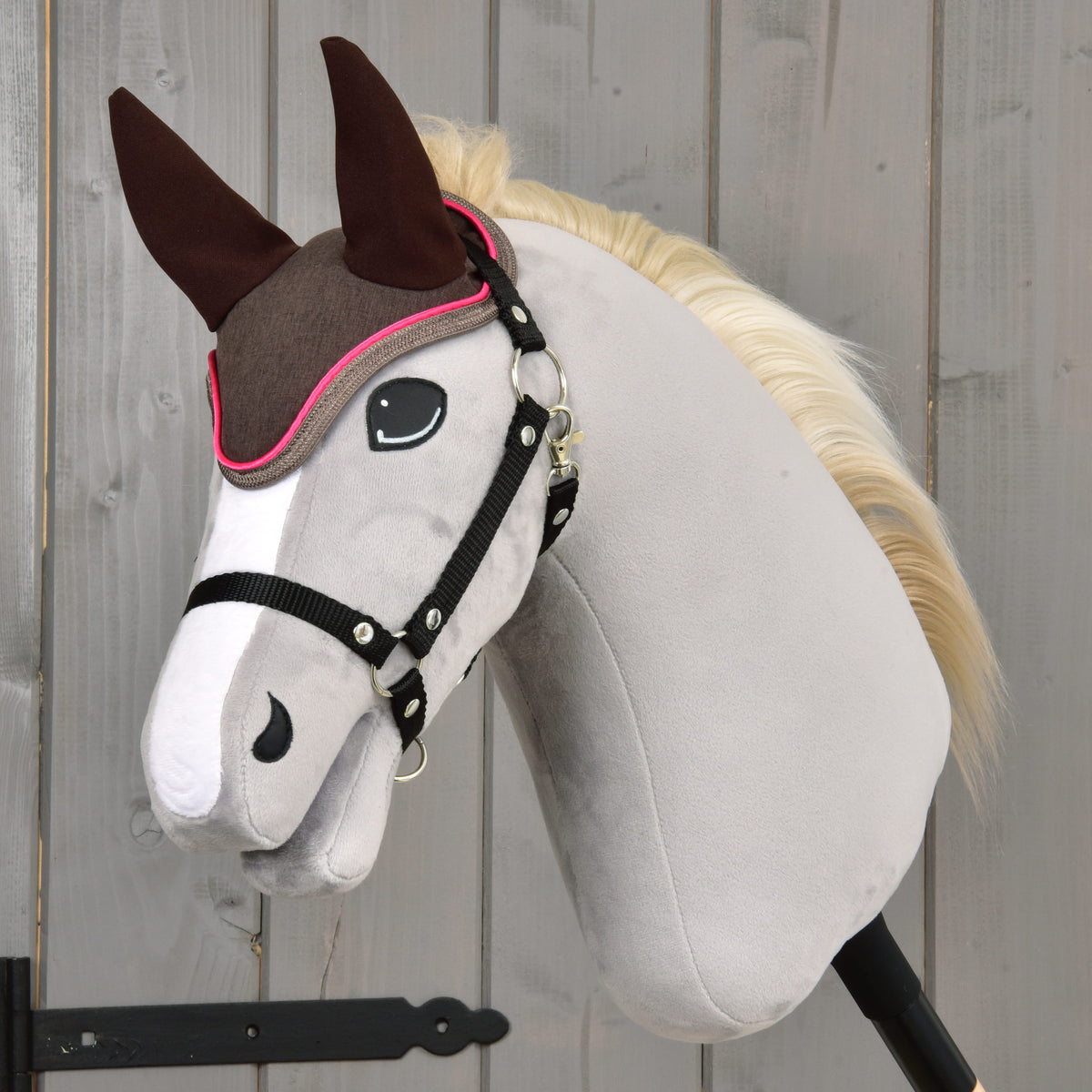 Hobby Horse gris à crinière crème et licol noir portant le bonnet d’oreilles marron Chocolat à passepoil rose vif
