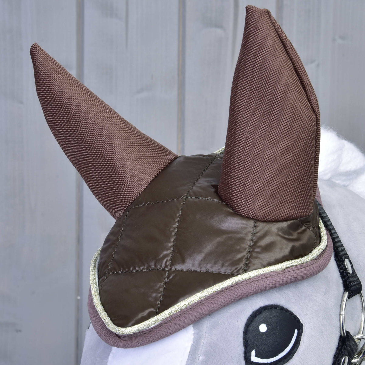 Close-up of the Hobby Horse Set Thermo Chocolate ear bonnet: quilted brown top, brown fabric ears and gold-edged trim