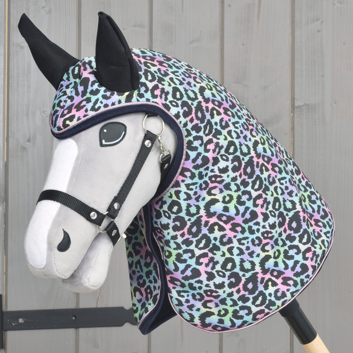 Lichtgrijze Hobby Horse met zwarte halster in de regenjas Confetti, met pastel luipaardprint over hoofd en hals
