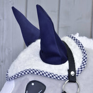 Gros plan sur le bonnet d’oreilles en sherpa blanc aux oreilles marine et bordure vichy, sur un Hobby Horse gris au licol noir