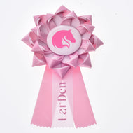 Ruban Hobby Horse LarDen Pink, cocarde en satin rose clair avec tête de cheval rose sur badge blanc et trois rubans dentelés