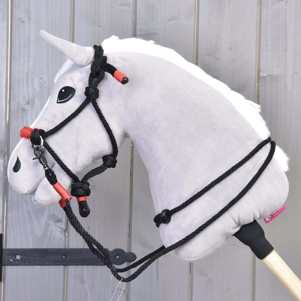 Lichtgrijze Hobby Horse met de Touwset Spark: zwart touwhalster met rode omwikkelingen en zwarte touwteugels