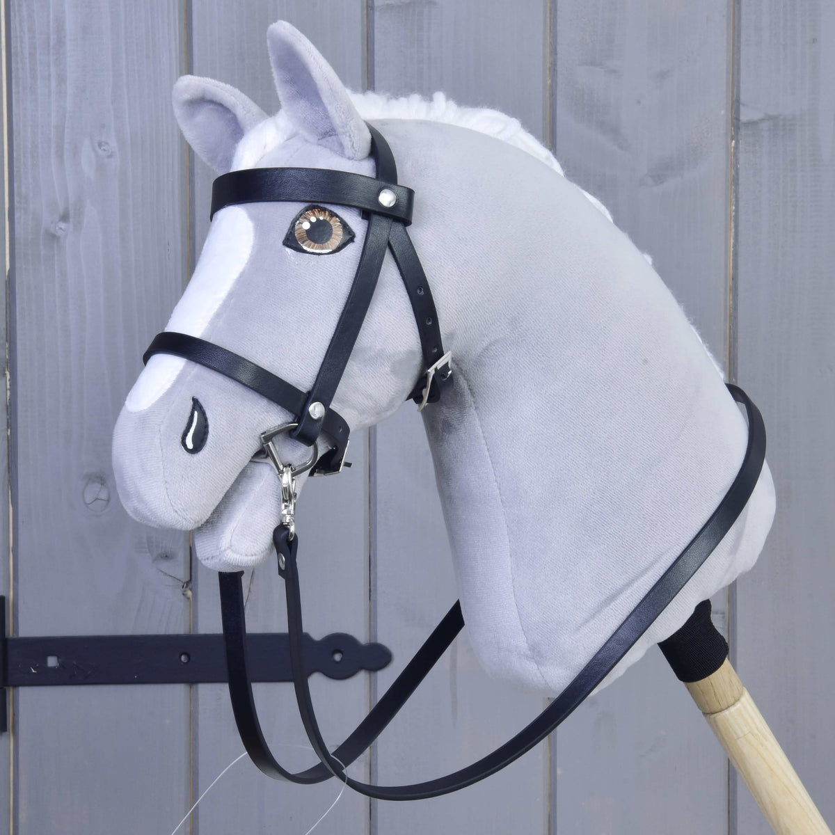 Grijze Hobby Horse met bruine ogen in het hoofdstel uit de Set Basic met lange zwarte teugels op een houten stok