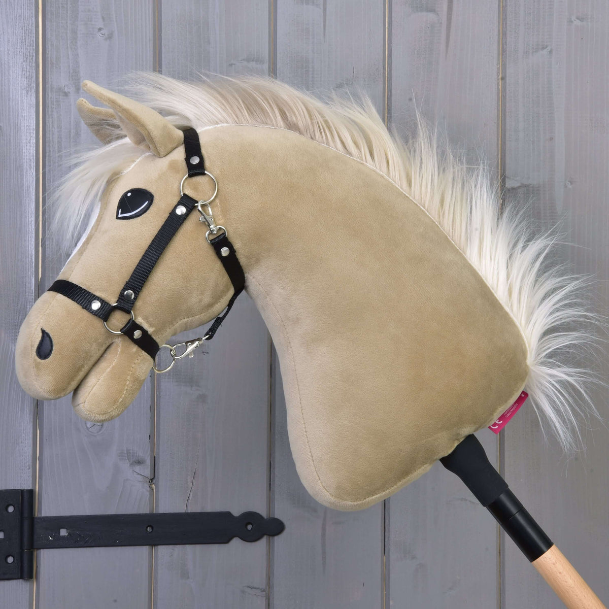 Hobby Horse Dancing Lady avec licol noir de profil, tête baissée, longue crinière crème duveteuse et bâton en bois