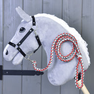 Grijze Hobby Horse met witte manen en zwart halster, het rood-wit gevlochten halstertouw vastgeklikt en over de hals gelegd