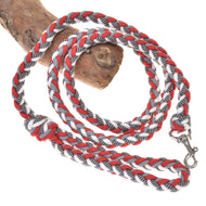Hobby Horse gevlochten halstertouw rood/wit van LarDen van rood, wit en grijs koord met zilveren karabijnhaak, over een tak