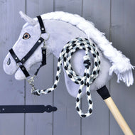 Een grijze pluche Hobby Horse met zwarte halster en het gevlochten zwart-wit-grijze halstertouw vastgeklikt en opgerold