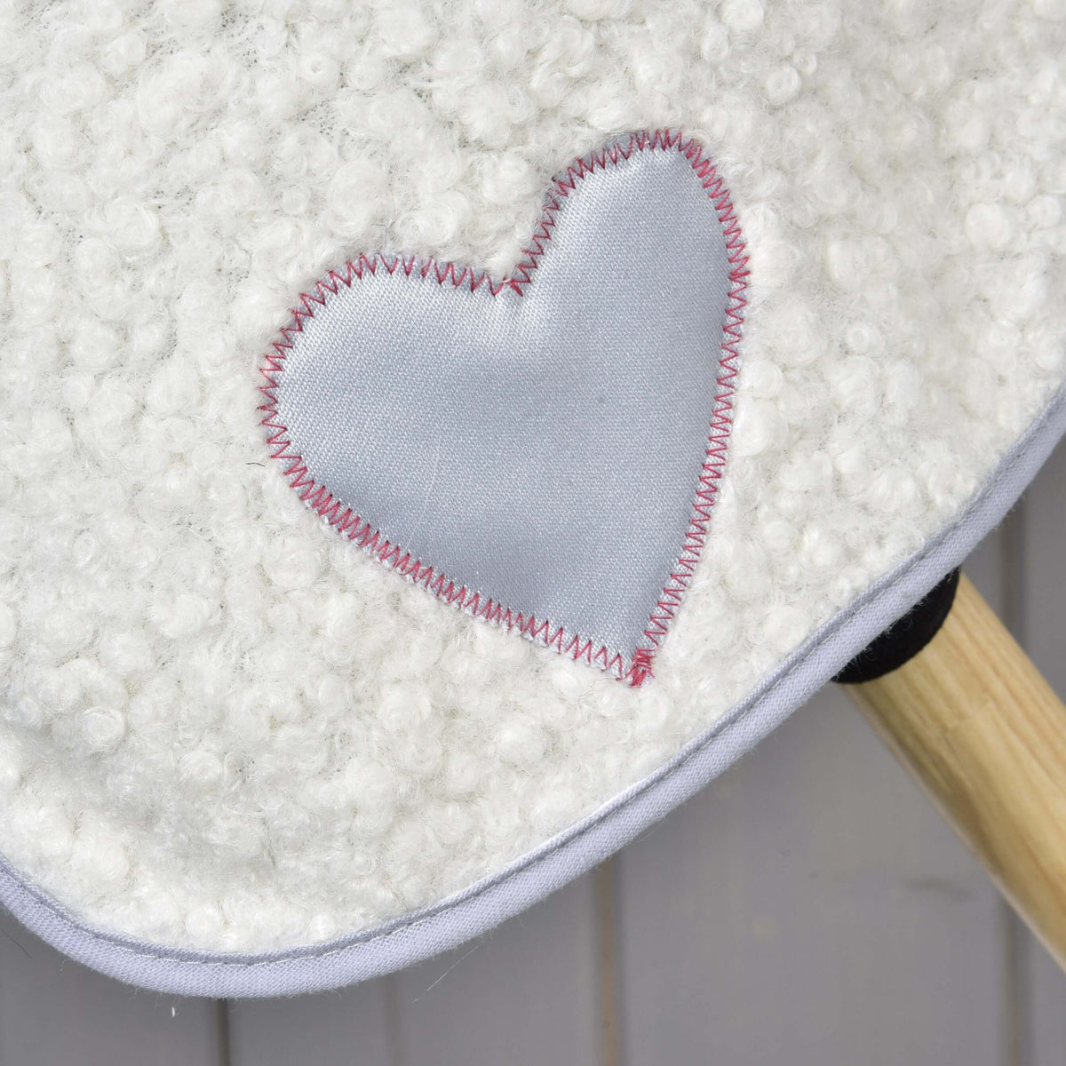 Close-up of the grey satin heart with pink zigzag stitching on the Hobby Horse Set Snowflake blanket