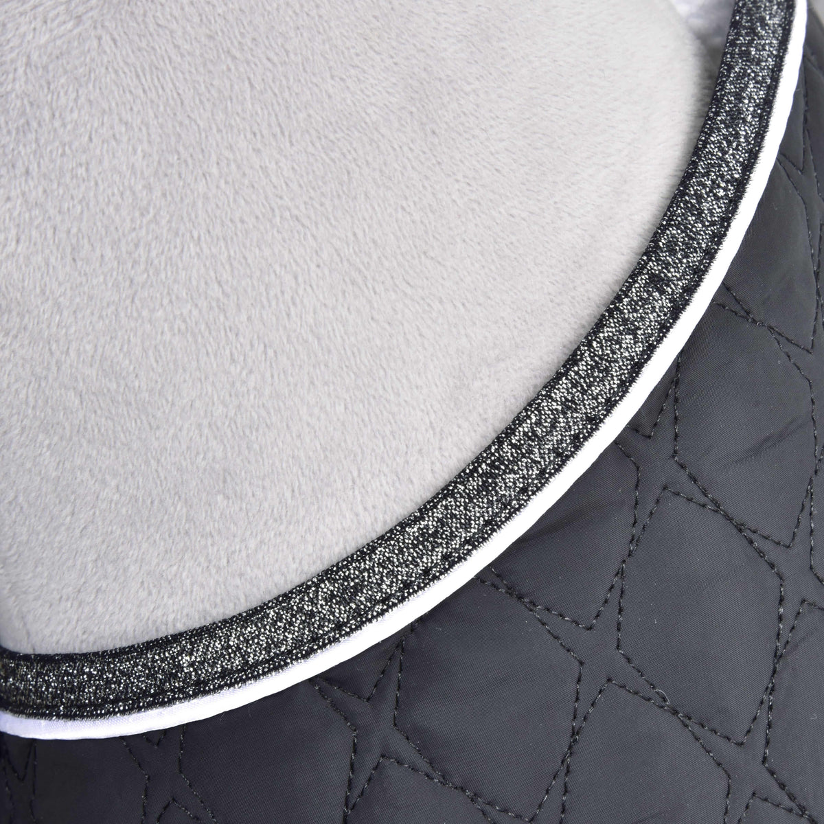 Close-up van de hals van de Set Thermo Black Queen: glinsterende zilveren rand en witte bies op zwarte gewatteerde stof