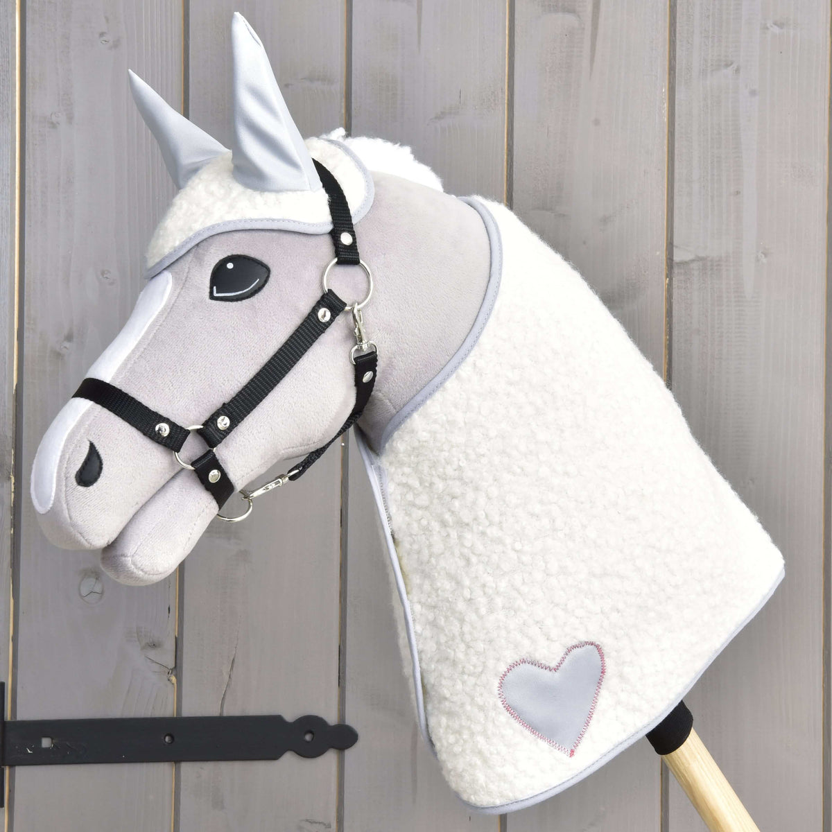 Grey Hobby Horse in a black halter wearing the Set Snowflake, a cream fleece blanket with grey heart and matching ear bonnet