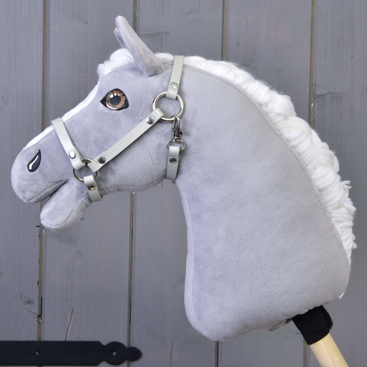 LarDen Halter - light grey leatherette on a grey plush Hobby Horse with a fluffy white mane, grey wooden wall