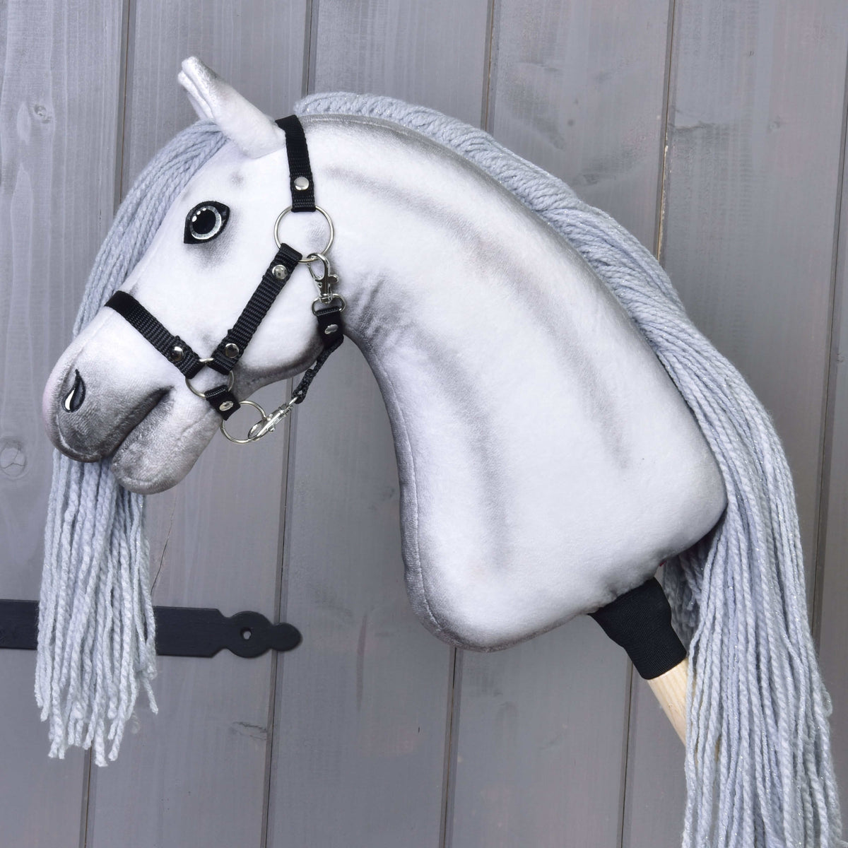 Hobby Horse Licorne Silver de profil avec licol noir en sangle, encolure ombrée de gris et longue crinière grise, sur un bâton