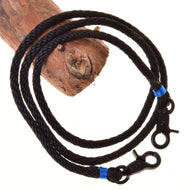 Hobby Horse teugels Azure van LarDen van zwart gevlochten touw met felblauwe omwikkeling en zwarte karabijnhaken over een tak
