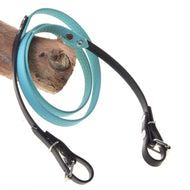Hobby Horse teugels gerubberd turquoise van LarDen met honingraatstructuur, zwarte uiteinden en gespen, over een tak