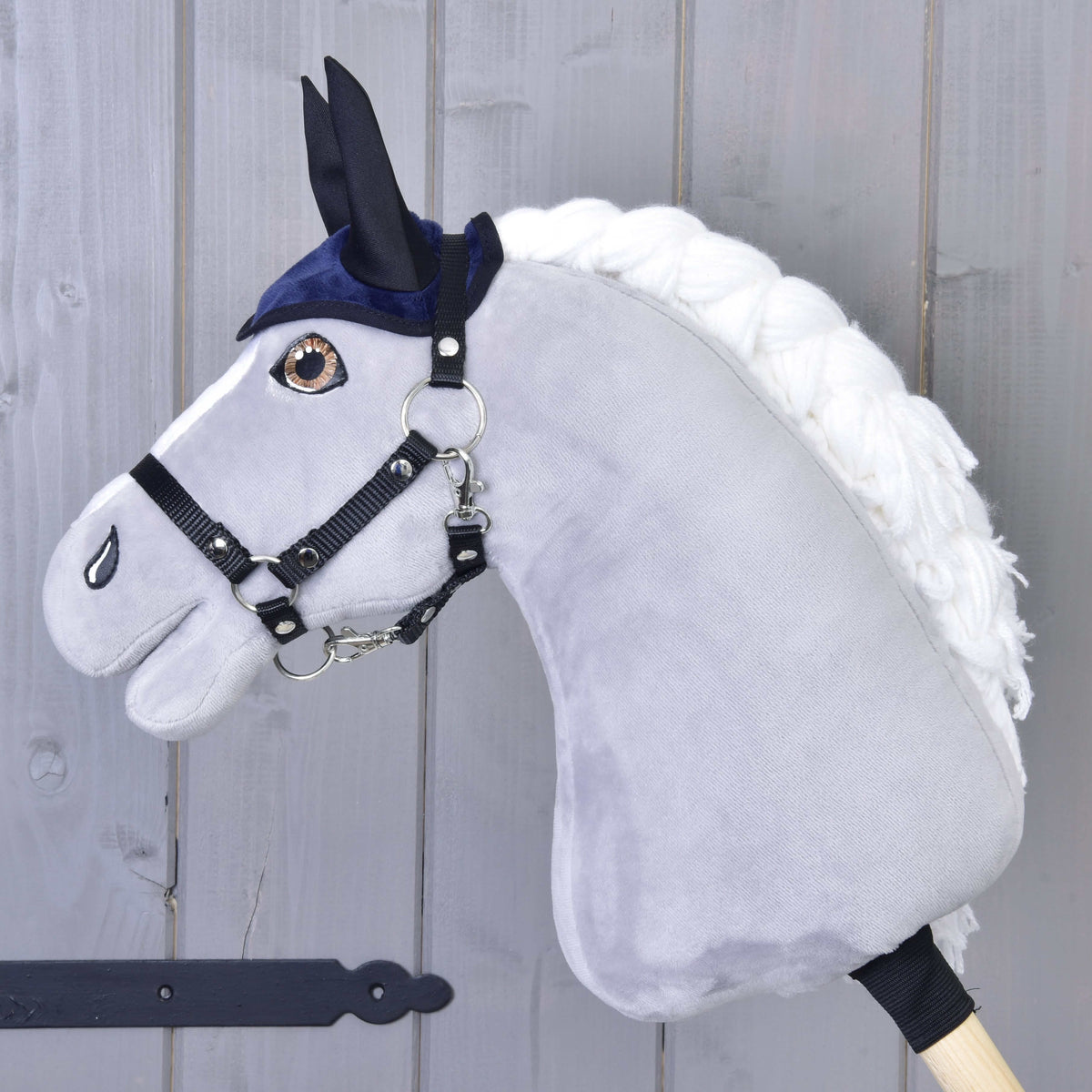 Grijze Hobby Horse met zwart halster die alleen het donkerblauwe oornetje met zwarte oren draagt