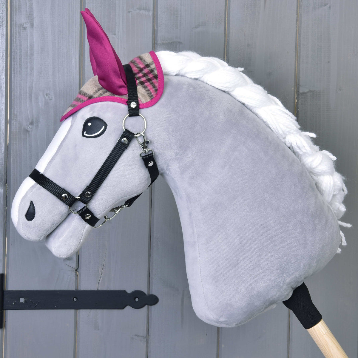 Grijze Hobby Horse met zwart halster die alleen het geruite oornetje met roze oren en roze bies draagt