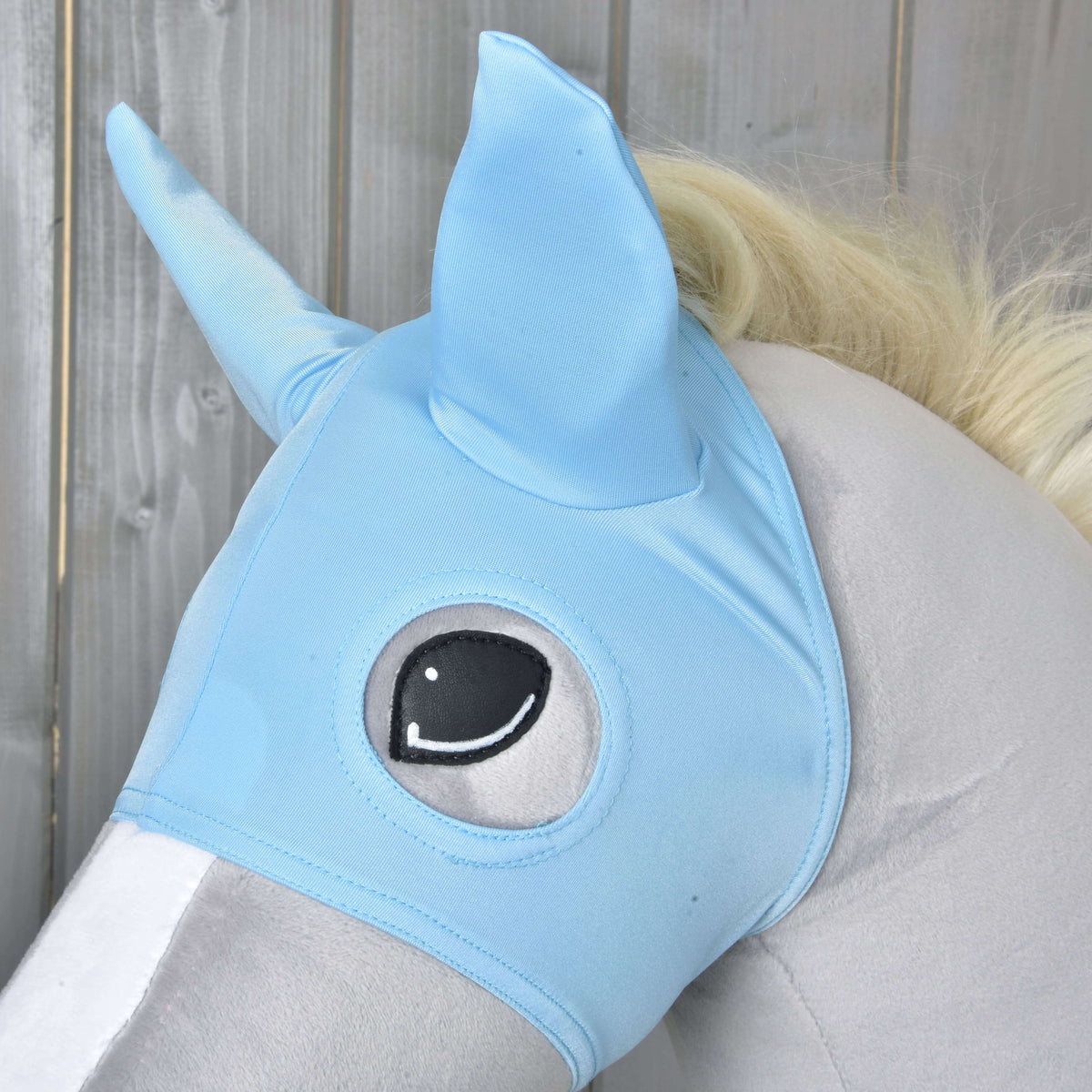 Close-up van het Paardenmasker Sky: lichtblauwe stretchstof met puntige oren en een gestikt rond ooggat