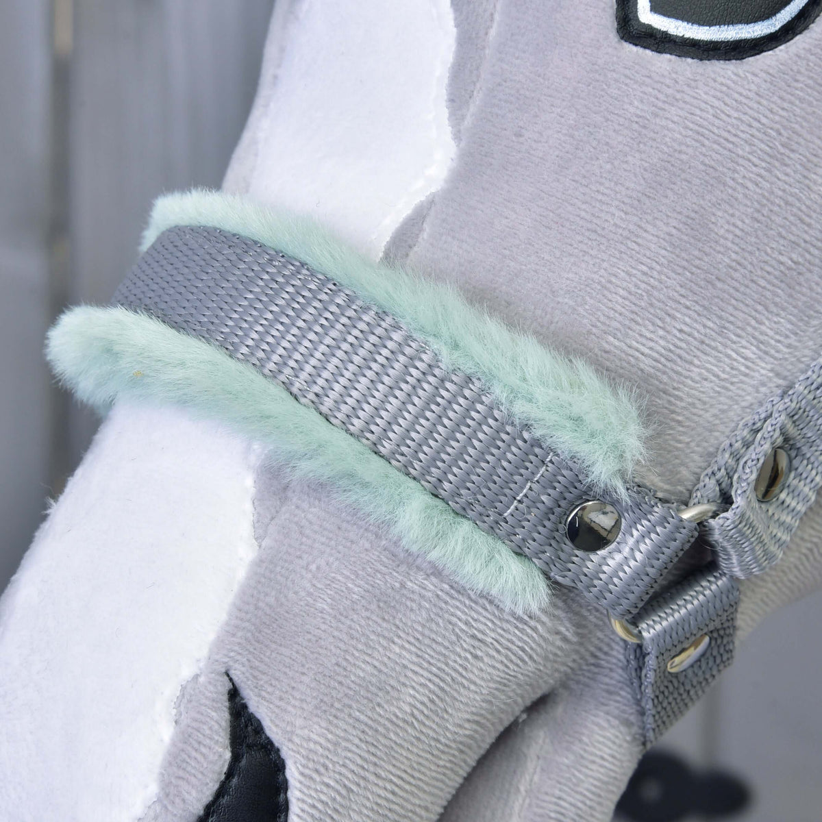 Close-up van de grijze neusriem met zacht mintgroen bont en een zilveren klinknagel op een grijze pluche Hobby Horse