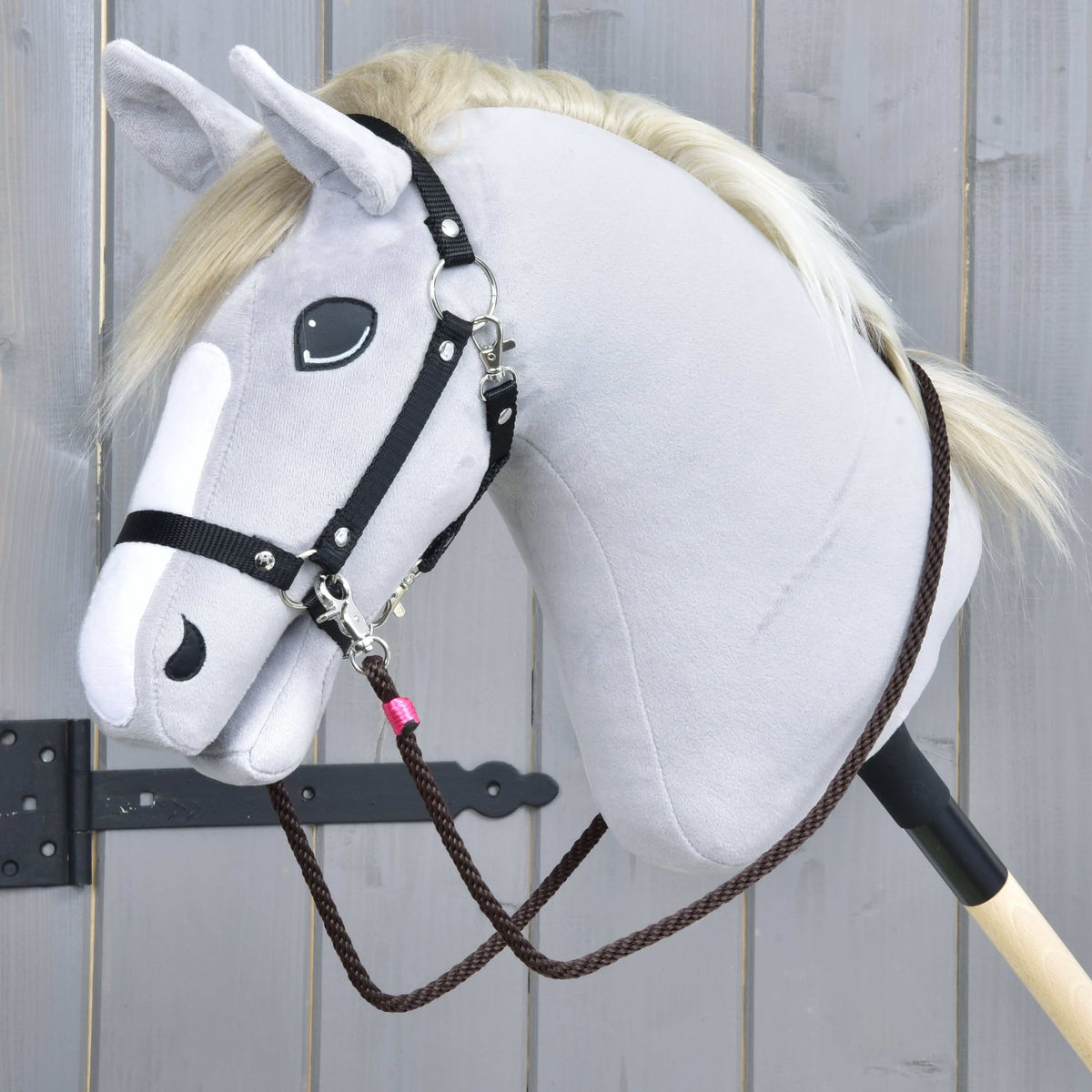 Bruine touwteugels van de Touwset Noir Cocoa aan een zwarte halster van band op een grijze Hobby Horse, met roze omwikkeling bij de karabijn