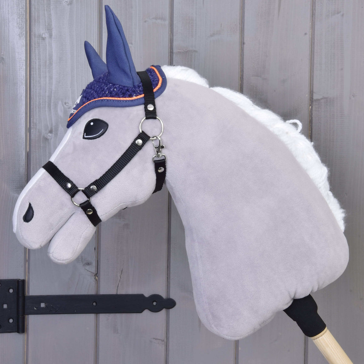 Hobby Horse gris à crinière blanche et licol noir vu de profil, avec le bonnet d’oreilles au crochet Blue Sport