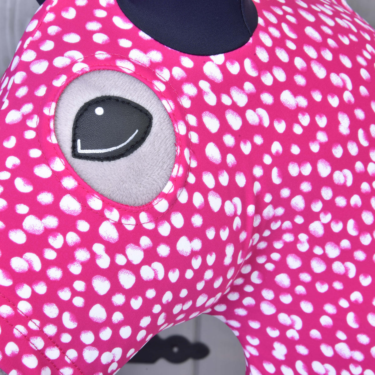 Close-up of the eye opening and white-spotted pink Lycra of the Minie protective suit on a Hobby Horse