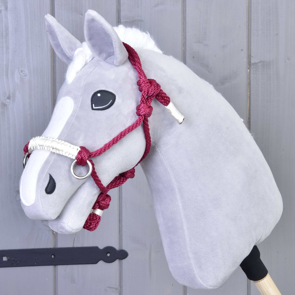 Grey plush Hobby Horse wearing the burgundy Czi-Czi rope halter with a white wrapped noseband