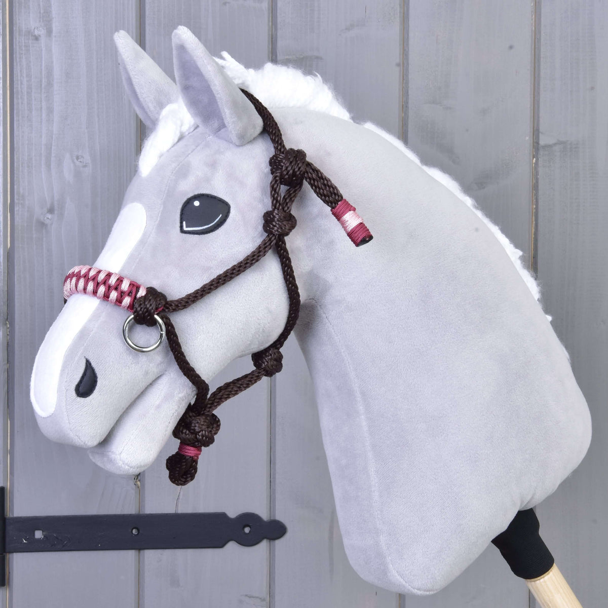 Hobby Horse gris en peluche portant le licol en corde York marron foncé à muserolle tressée rose et bordeaux