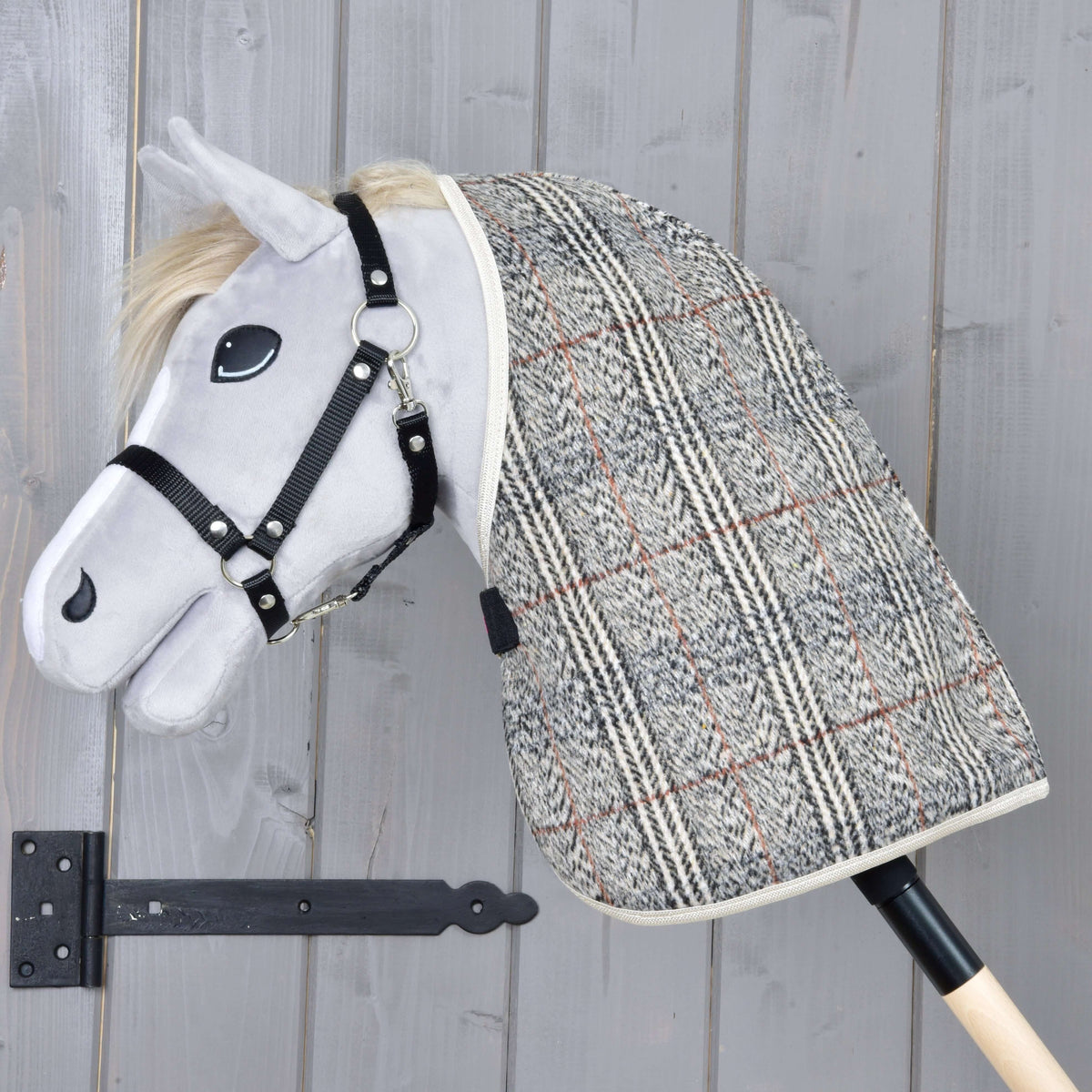 Light grey Hobby Horse in a black halter wearing the Stable Blanket Fine Check, grey herringbone check with beige binding
