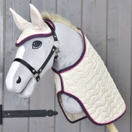 Light grey Hobby Horse in a black halter wearing the Set Supreme Crema, a cream quilted blanket and matching ear bonnet