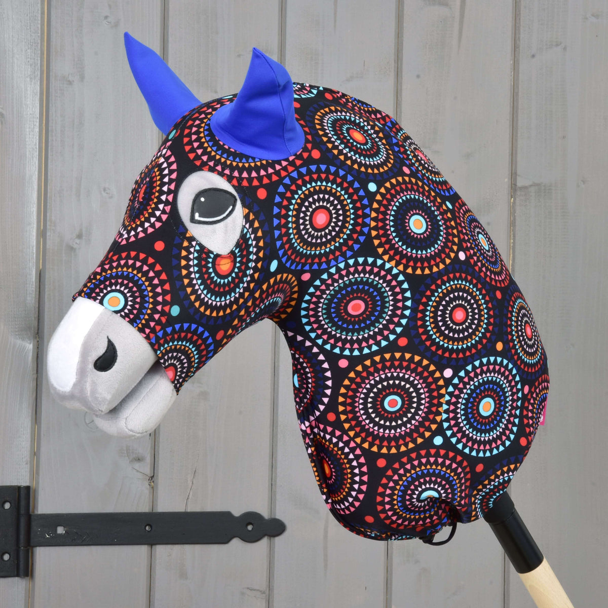 Hobby Horse beschermpak Alice (Lycra) van LarDen, zwart met kleurrijke mandalacirkels en koningsblauwe oren, op een grijze Hobby Horse