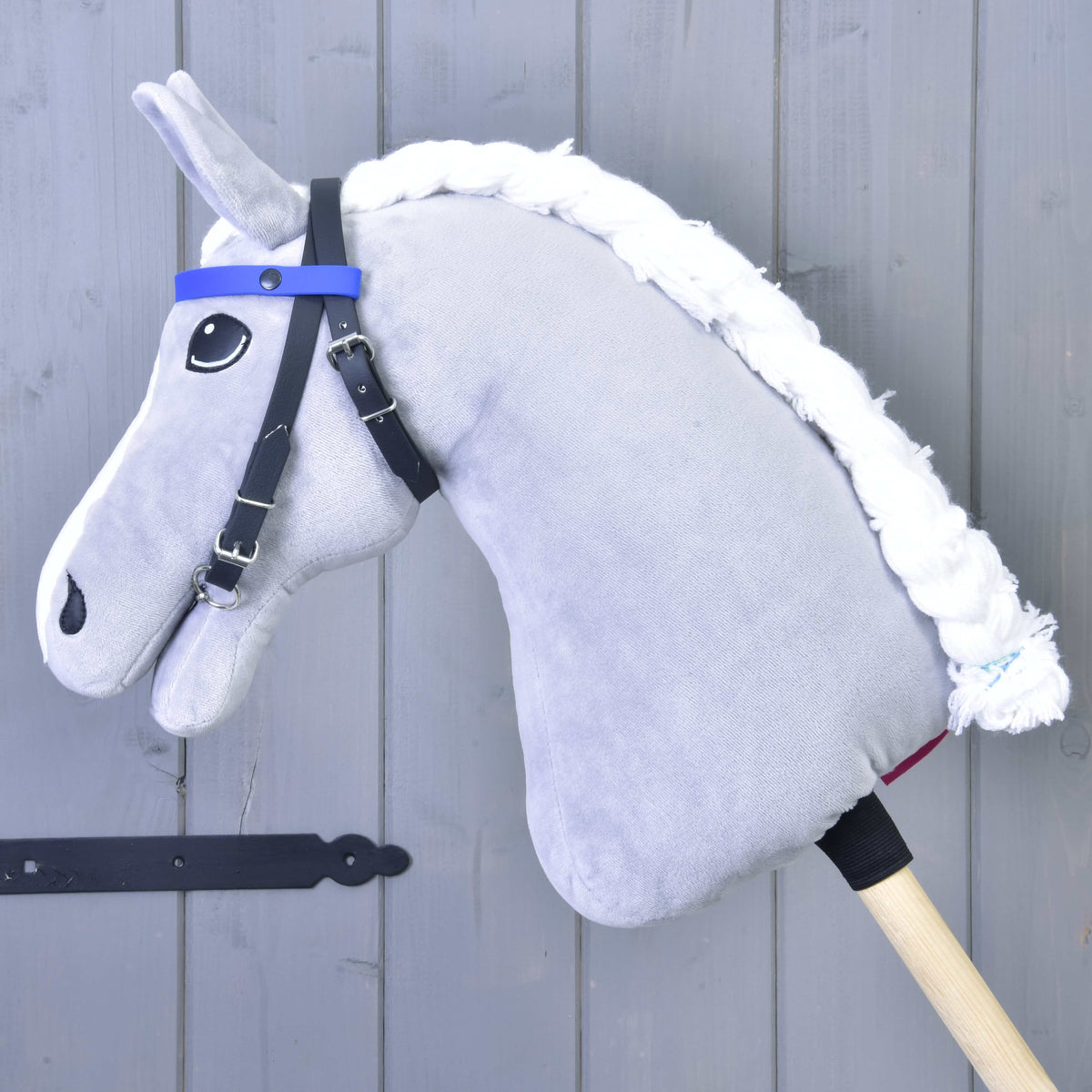 Hoofdstel met 2 hoofdbanden blauw van LarDen op een grijze pluche Hobby Horse, zwarte riemen en effen blauwe hoofdband