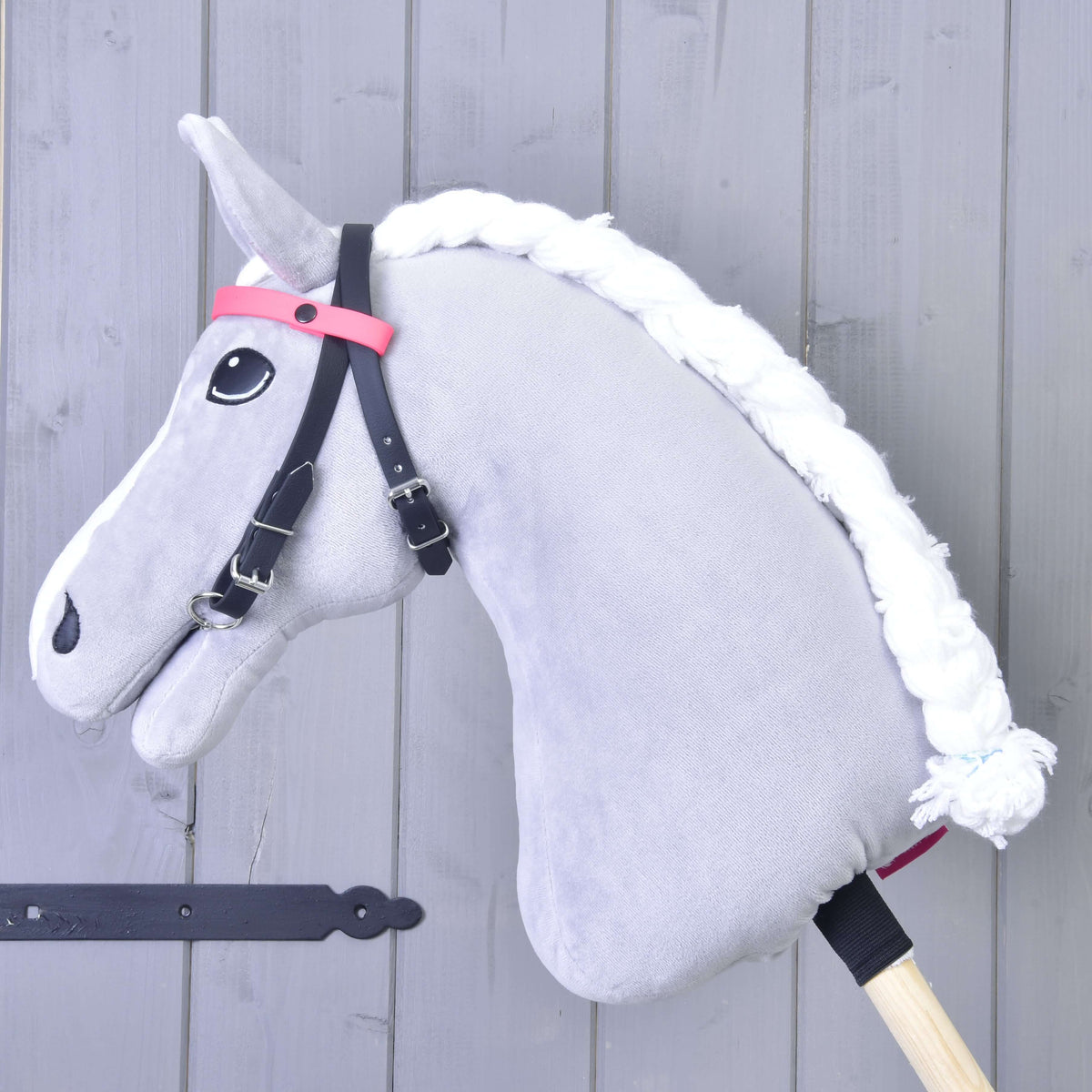 Hoofdstel met 2 hoofdbanden roze van LarDen op een grijze pluche Hobby Horse, zwarte riemen en effen roze hoofdband