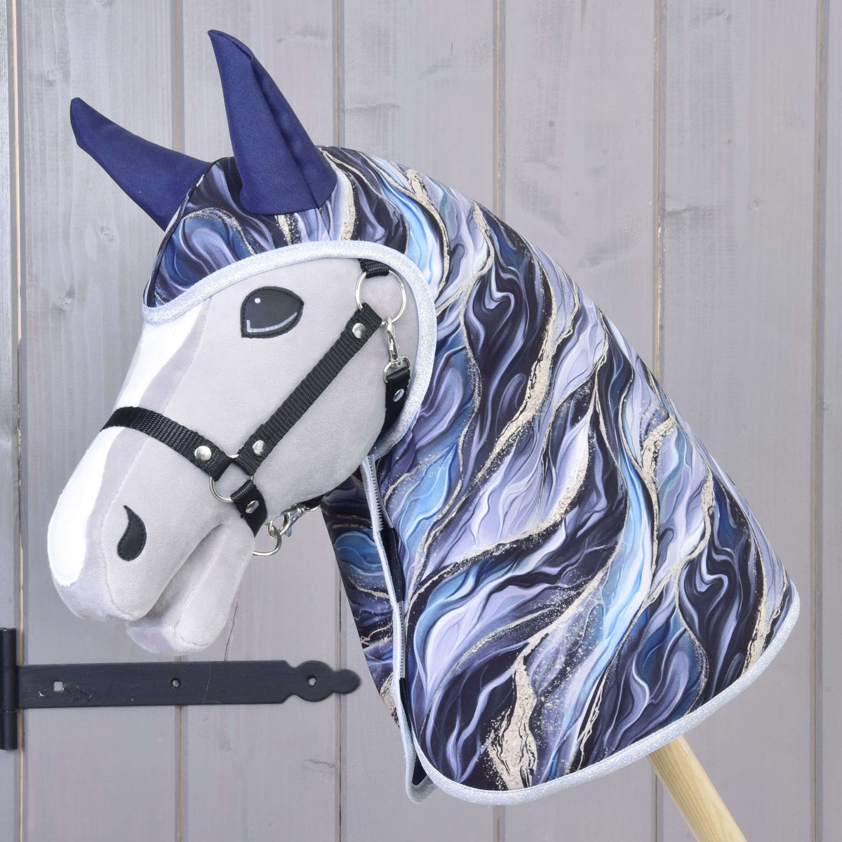 Hobby Horse gris avec licol noir portant l’imperméable Galaxy Cobalt, dont l’imprimé marbré bleu couvre la tête et l’encolure