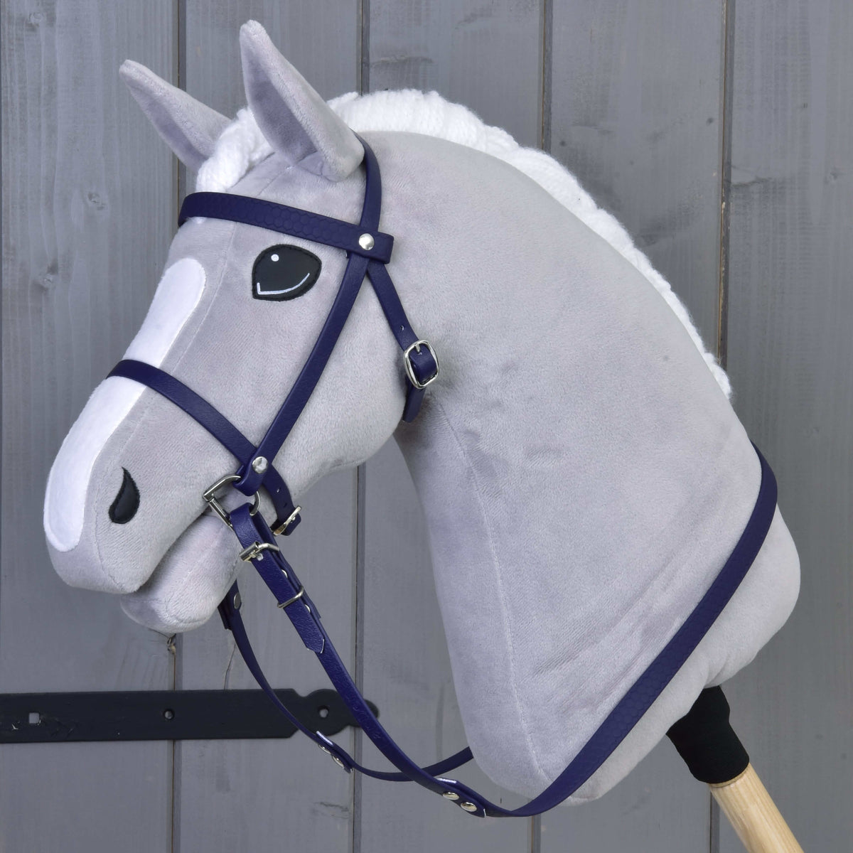 Bride complète avec muserolle Dark Purple LarDen avec rênes sur un Hobby Horse gris à liste et crinière blanches