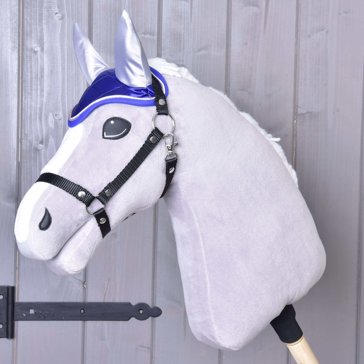 Grijze pluche Hobby Horse met witte manen en zwart halster draagt het koningsblauwe satijnen oornetje DeLuxe Blue
