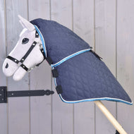 Hobby Horse gris avec licol noir portant la couverture matelassée bleu marine avec couvre-cou attaché, bordure bleue et blanche