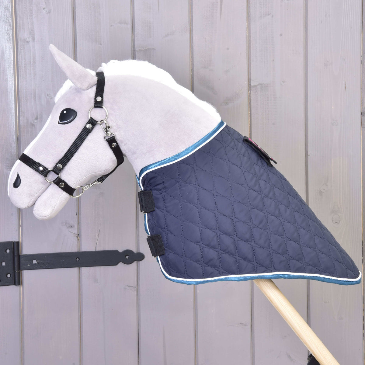 Grey Hobby Horse wearing the navy quilted blanket without its neck cover, Velcro straps closed at the chest